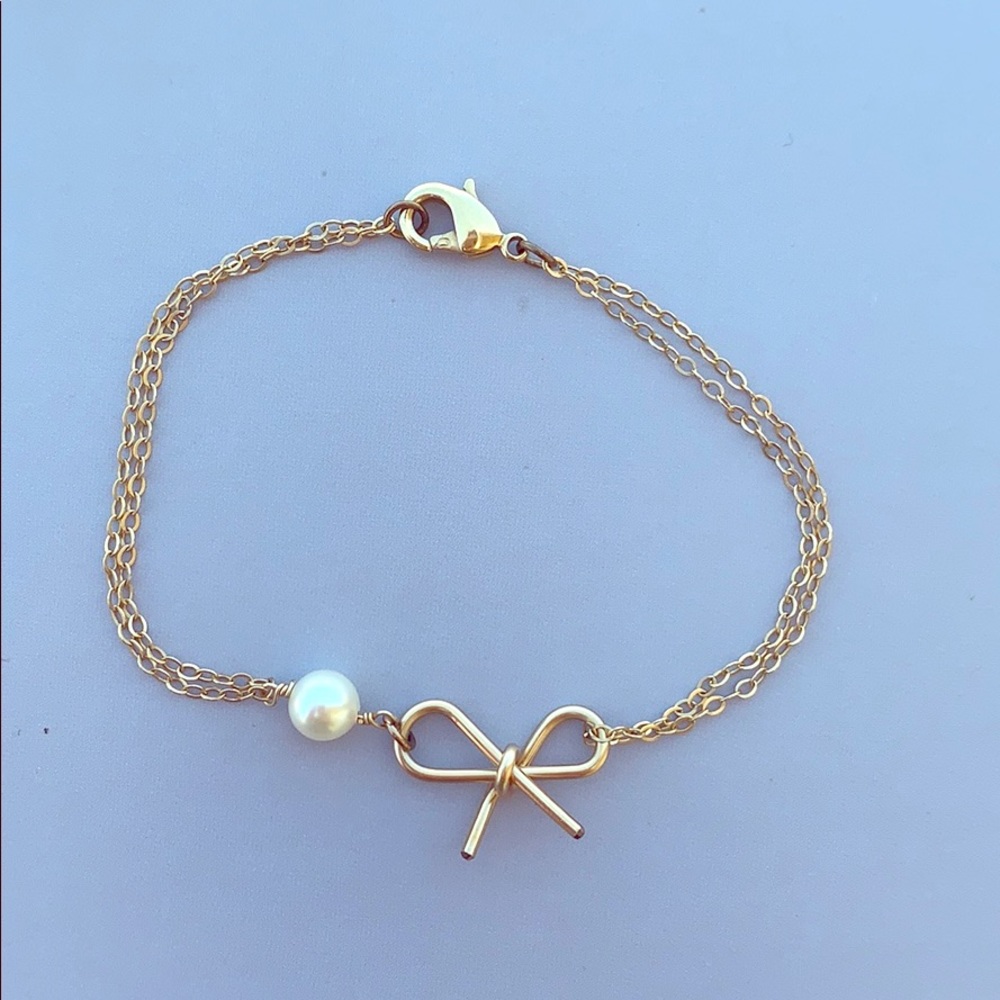 Dainty gold bracelet with bow and pearl